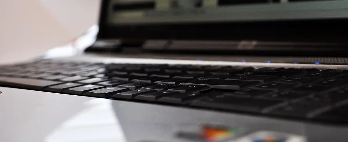 Gros plan sur le clavier d'un ordinateur portable posé sur un bureau de travail